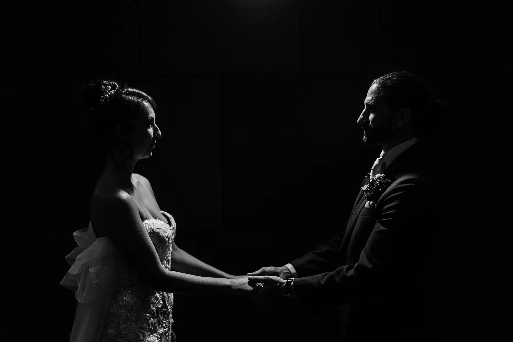 Bride and groom holding hands in silhouette